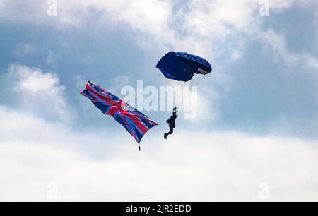 Ein Mitglied des Teams der Tigers Army Fallschirm-Ausstellung fliegt die Union Jack-Flagge, als er bei der jährlichen Eastbourne Airshow, einer der großen, landet Stockfoto