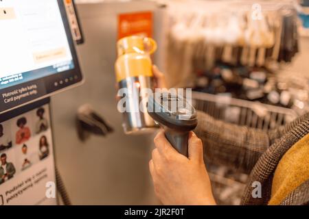 Die Kundin scannt die Thermosflasche an der Selbstbedienungskasse im Supermarkt Stockfoto