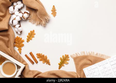 Herbst Winter Komfort am Arbeitsplatz. Kaschmir Schal Tastatur Kaffee Tasse mit Eichenlaub auf dem Tisch. Stockfoto