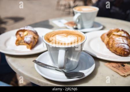 Italienisches Frühstück für zwei Personen: Cappuccino und Croissant Stockfoto