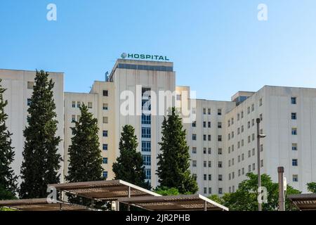 Granada, Spanien; August-2022: Hauptfassade des allgemeinen Krankenhauses des Universitätskomplexes Virgen de las Nieves in Granada (Spanien) an einem sonnigen Sommer Stockfoto