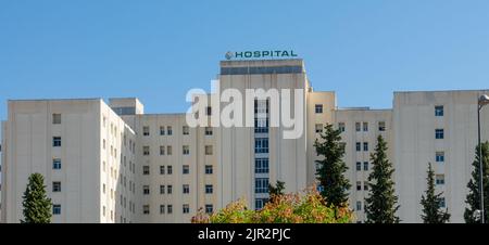 Granada, Spanien; August-2022: Hauptfassade des allgemeinen Krankenhauses des Universitätskomplexes Virgen de las Nieves in Granada (Spanien) an einem sonnigen Sommer Stockfoto