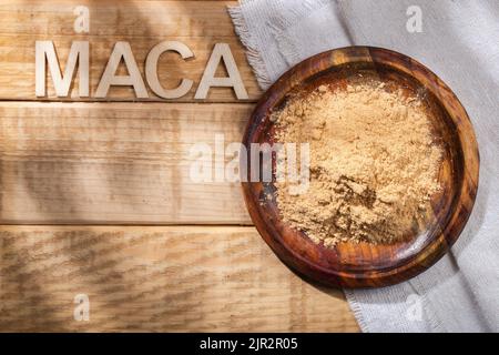 Maca-Pulver, in Holzschale auf dem Tisch, Nährstoff aus Peru. Stockfoto