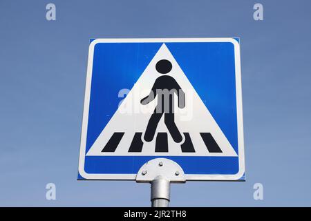 Nahaufnahme eines finnischen Straßenschilds für genderlose Fußgängerübergänge. Stockfoto