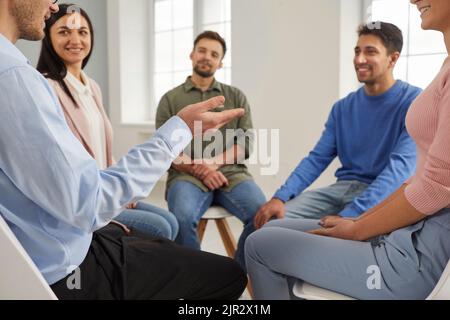 Eine Gruppe glücklicher junger Menschen, die während eines Geschäftstreffens im Büro ein Gespräch führen Stockfoto