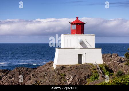 Leuchtturm an der Rocky Pacific Ocean Coast bei einem bunt bewölkten Sonnenaufgang. Stockfoto