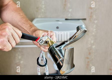 Reparaturarbeiten im Badezimmer, Installateur Installation neuer Wasserhahn in Haus Wasserversorgungssystem. Stockfoto