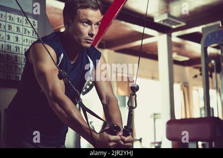 Hübscher junger fit Mann, der im Fitnessstudio trainiert Stockfoto