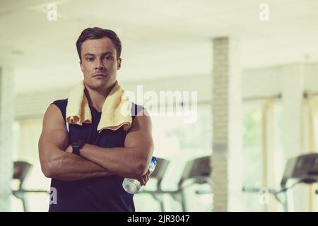 Porträt eines selbstbewussten jungen Fitnesstrainers im Fitnessstudio Stockfoto