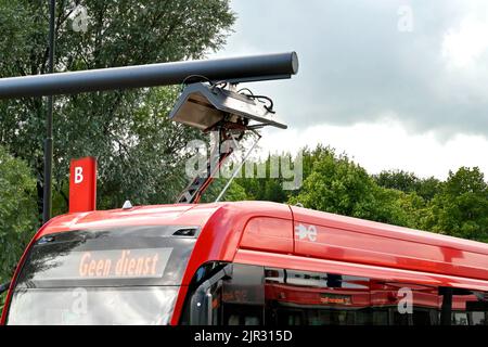 Edam, Niederlande - August 2022: Nahansicht eines Elektrobusses am Busbahnhof der Stadt, um seine Batterien mit einem Schnellladegerät aufzuladen Stockfoto