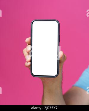 Nahaufnahme Mann Hand hält Smartphone mit weißen leeren Bildschirm und schwarze Handytasche. Isoliert auf rosa Hintergrund. Rahmenloses Design-Konzept für Handy-App-Werbung. Speicherplatz kopieren. Stockfoto