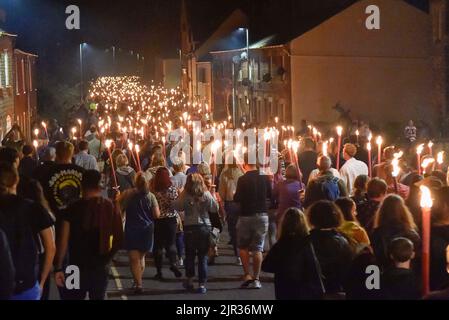 Bridport, Dorset, Großbritannien. 21.. August 2022. Hunderte von Feiernden kommen zur jährlichen Bridport Carnival Fackelparade in Bridport in Dorset, die nach drei Jahren Abwesenheit aufgrund der Covid-19-Pandemie zurückkehrt. Die Fackelparade geht vom Rathaus in Bridport nach East Beach in West Bay. Bildnachweis: Graham Hunt/Alamy Live News Stockfoto