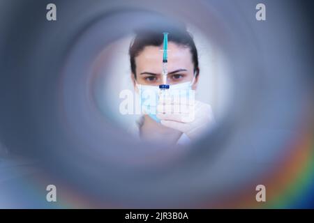 Ärztin bereitet Spritze vor. Schöne Krankenschwester, die eine Spritze vorbereitet Stockfoto