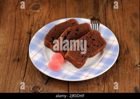 Stücke von hausgemachten Schokoladenkuchen mit rosa Süßigkeiten auf Holz Hintergrund horizontal Stockfoto