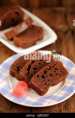 Hausgemachte Schokoladenkuchen mit rosa Süßigkeiten auf Holzhintergrund selektiven Fokus vertikal geschnitten Stockfoto