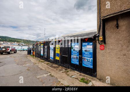 Anzeige für Lyme Bay Bootsfahrten auf der Cobb bei Lyme Regis, einer beliebten Küstenstadt in Dorset an der Jurassic Coast im Südwesten Englands Stockfoto