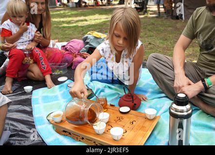 Prag, Tschechische Republik. 21. August 2022. Ein Kind gießt am 21. August 2022 eine Tasse Minztee während des internationalen Teestivals „Colomir Fest“ in Prag, Tschechien. Quelle: Dana Kesnerova/Xinhua/Alamy Live News Stockfoto