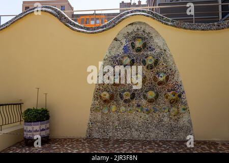 Eine schöne Aufnahme einer Gartenmauer mit bunten Fliesen in der Casa Batllo Stockfoto