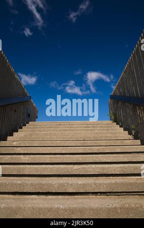 Zementstufen führen zu blauem Himmel und Wolken. Stockfoto