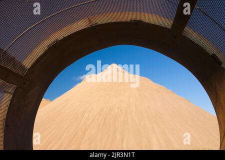 Sandhügel durch einen Metallestrich im kommerziellen Sandkasten. Stockfoto