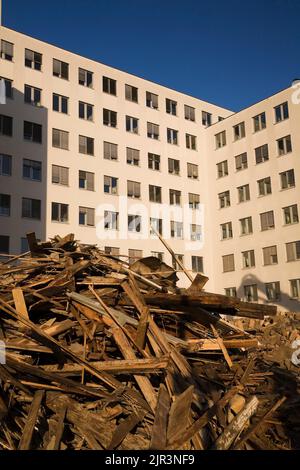 Alte und weggeworfene Holzschutt vor einem modernen Architekturgebäude in Wien, Österreich. Stockfoto