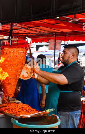 Mann, der Al-Pastor-Fleisch (mexikanische Version des libanesischen Shawarma) zubereitet, Lucas de Galvez-Markt, Merida, Mexiko Stockfoto