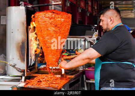 Mann, der Al-Pastor-Fleisch (mexikanische Version des libanesischen Shawarma) zubereitet, Lucas de Galvez-Markt, Merida, Mexiko Stockfoto