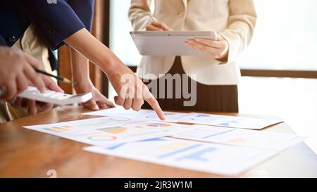 Eine Gruppe talentierter Geschäftsleute, die im Büro an finanziellen Aufgaben mitwirken und die finanziellen Investitionen des Unternehmens gemeinsam analysieren und planen. Stockfoto