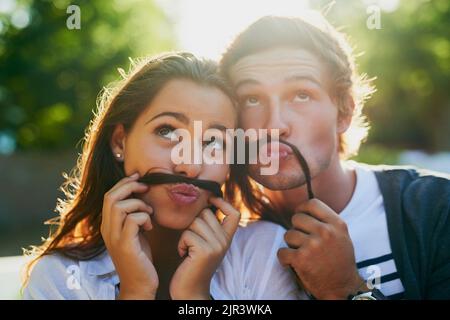 Ein junges Paar genoss einen dummen Moment zusammen, während sie sich im Freien festklebten. Stockfoto