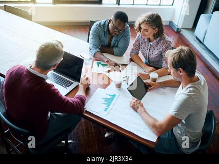 Unsere Gedanken zusammenbringen. Ein kreatives Geschäftsteam, das im Büro ein Meeting abhalten und geschäftliche Themen besprechen kann. Stockfoto