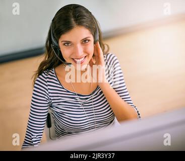 Es gibt kein Problem, das ich nicht lösen kann. Hochwinkelporträt einer attraktiven jungen Frau, die in einem Callcenter arbeitet. Stockfoto