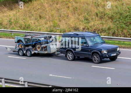 1952 Serie II 2a Land Rover Karosserie Shell Restaurierung Projekt auf Anhänger, die von 2004 blauen Land Rover Discovery geschleppt. Autotransporter, Transport, Auto-Schlepper, Schleppfahrzeug, Auto-tragenden Anhänger, autotransportanhänger, Sattelauflieger auf der M6 Motorway, Großbritannien auf der Autobahn M6, Großbritannien Stockfoto