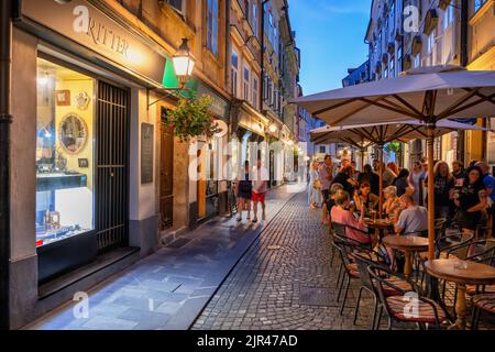 Ljubljana, Slowenien - 14. Juli 2022: Gruppe von Menschen, Touristen auf der belebten Straße des Alten Platzes (Stari Trg), gesäumt von Restaurants und Geschäften in der Altstadt Stockfoto