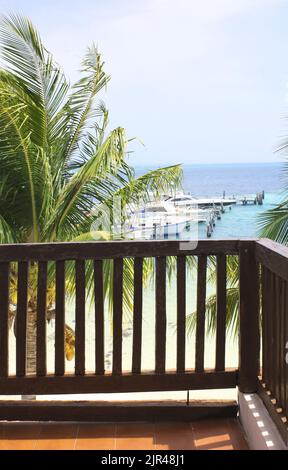 Blick auf Meer, Palmen und Yachten vom Balkon des Hauses am Strand. Zimmer mit Meerblick. Reise-, Resort-, Urlaubs- und Urlaubskonzept. Blick auf das tropische Meer von ver Stockfoto