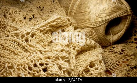 Leinengarn in einem Skein, einem gestrickten durchbrochenen Stoff. Nahaufnahme. Die Textur des Fadens zum Stricken Stockfoto