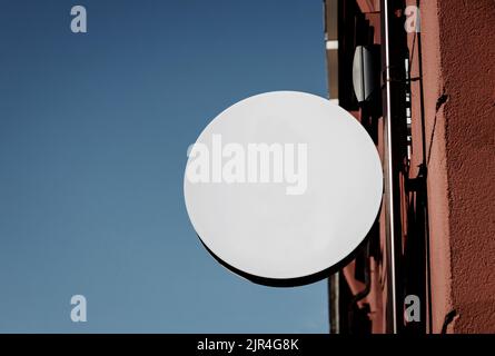 Blank weiß rund Geschäft Schild Mock up. Leere kreisförmige Shop-Leuchtkasten-Schablone an der Wand montiert. Ort für Text, Außenwerbung Stockfoto