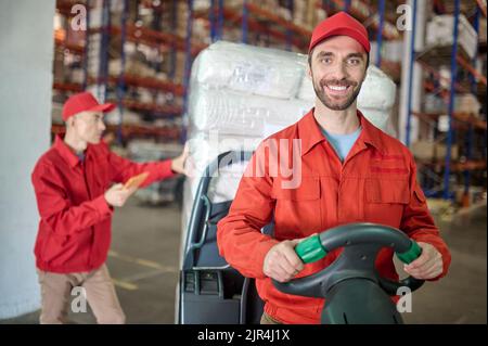 Zwei erfahrene Arbeiter, die Waren im Lager umziehen Stockfoto