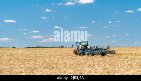 Traktor steht auf einem geernteten Feld Stockfoto
