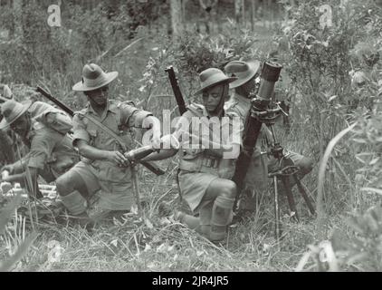 Ein Vintage-Foto aus dem Jahr 1941, das Soldaten der 9. Gurkha-Gewehre zeigt, die während der japanischen Invasion von Malaya und dem Fall Singapurs eine Mörserposition im Dschungel annahmen Stockfoto