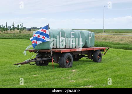 Melden Sie sich in landwirtschaftlichen Bereich mit Text Hilfe und Flagge. Landwirte in den Niederlanden protestieren gegen die erzwungene Schrumpfung von Nutztieren aufgrund von Emissionen im Jahr CO2 Stockfoto