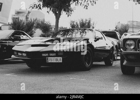 Eine Graustufenaufnahme des Pontiac Firebird Trans AM Autos auf einem Oldtimer-Parkplatz in Spa Stockfoto