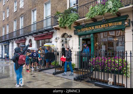 Leute, die an einem regnerischen Tag Schlange stehen, warten auf den Eintritt zum Sherlock Holmes Museum. Baker Street, London, England, Großbritannien Stockfoto