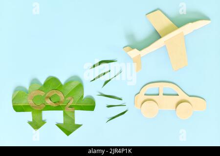 Konzept zur Reduzierung der CO2-Emissionen von Luft- und Landreisen oder der Transportindustrie. Flugzeug und Auto Fahrzeug Freigabe niedrig CO2 Symbol grünen Blatt Ausschnitt. Stockfoto