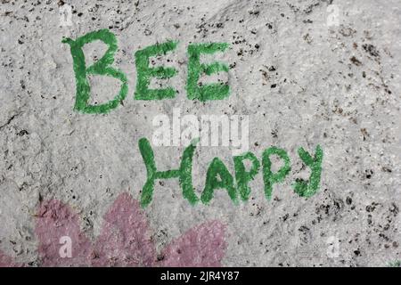 Biene glücklich auf einem Felsen als schöne Gartendekoration gemalt. Stockfoto