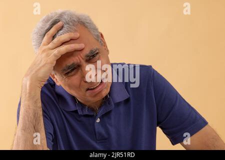 Nahaufnahme eines traurigen älteren Mannes, der mit der Hand auf dem Kopf weint Stockfoto