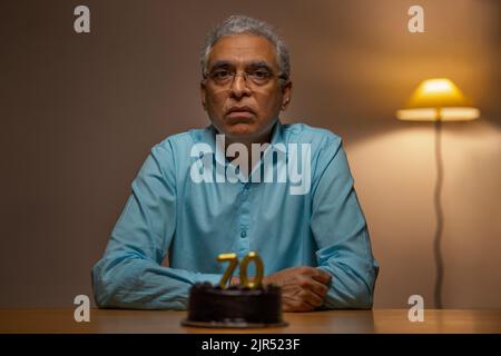 Älterer Mann, der seinen 70.. Geburtstag feiert Stockfoto