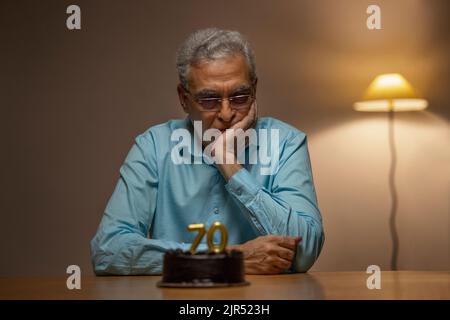 Älterer Mann, der seinen 70.. Geburtstag feiert Stockfoto