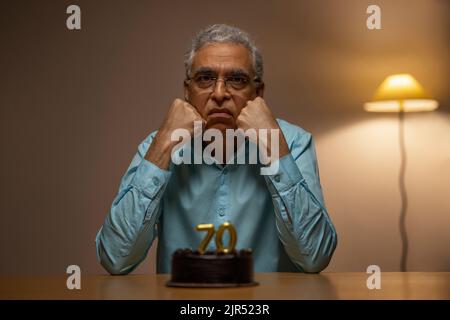 Älterer Mann, der seinen 70.. Geburtstag feiert Stockfoto
