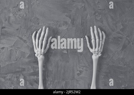 Mystery Halloween flach lag mit weißen Monster Skelett Hände auf dunkelgrauem Hintergrund. Fröhliches Halloween-Banner-Modell. Draufsicht, Kopierbereich Stockfoto