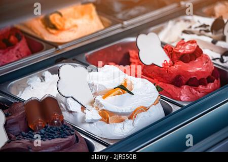 Eis in verschiedenen Farben und Geschmacksrichtungen im Kühlschrank im Fenster eines Dessertladens oder Gelateria in Italien. Leckeres und leckeres Eis im Café Stockfoto